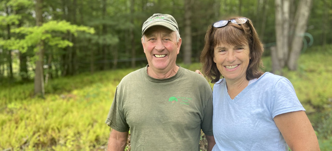 Photo of Tom and Cecile Branon standing at the edge of the forest
