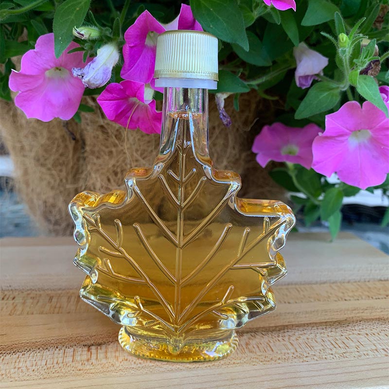 Photo of Maple Leaf favor bottle with pink petunias in background