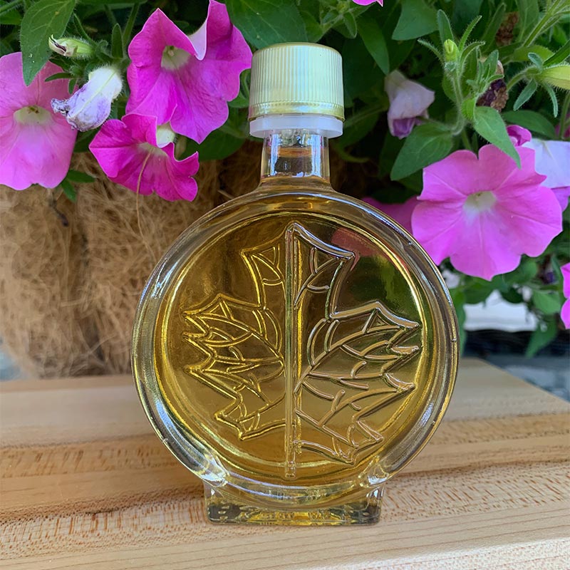 Photo of Modern Maple Leaf favor bottle with pink petunias in background
