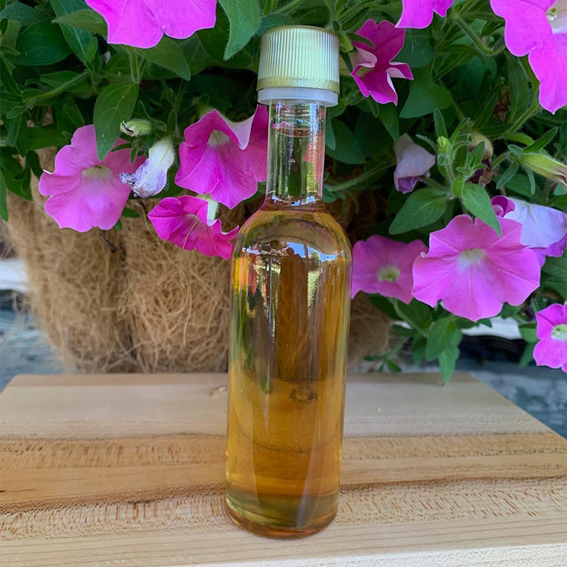 Photo of Ice Clear favor bottle with pink petunias in background